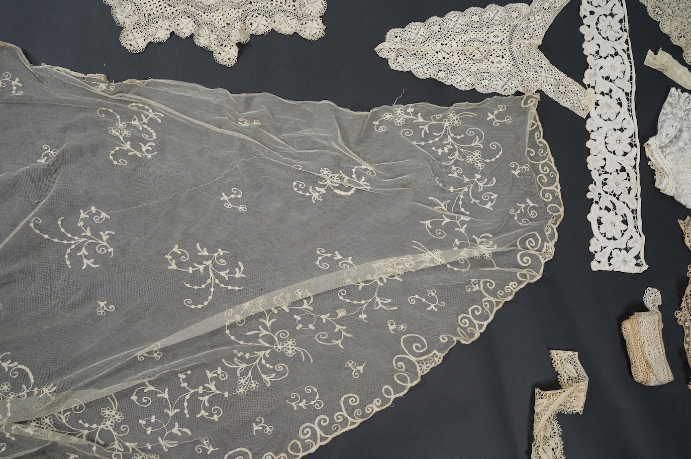 A needle run embroidered net skirt, a similar Bertha, five large silk Maltese bobbin lace collars and trimming, a length of Venetian style lace, mittens etc. Condition - good
